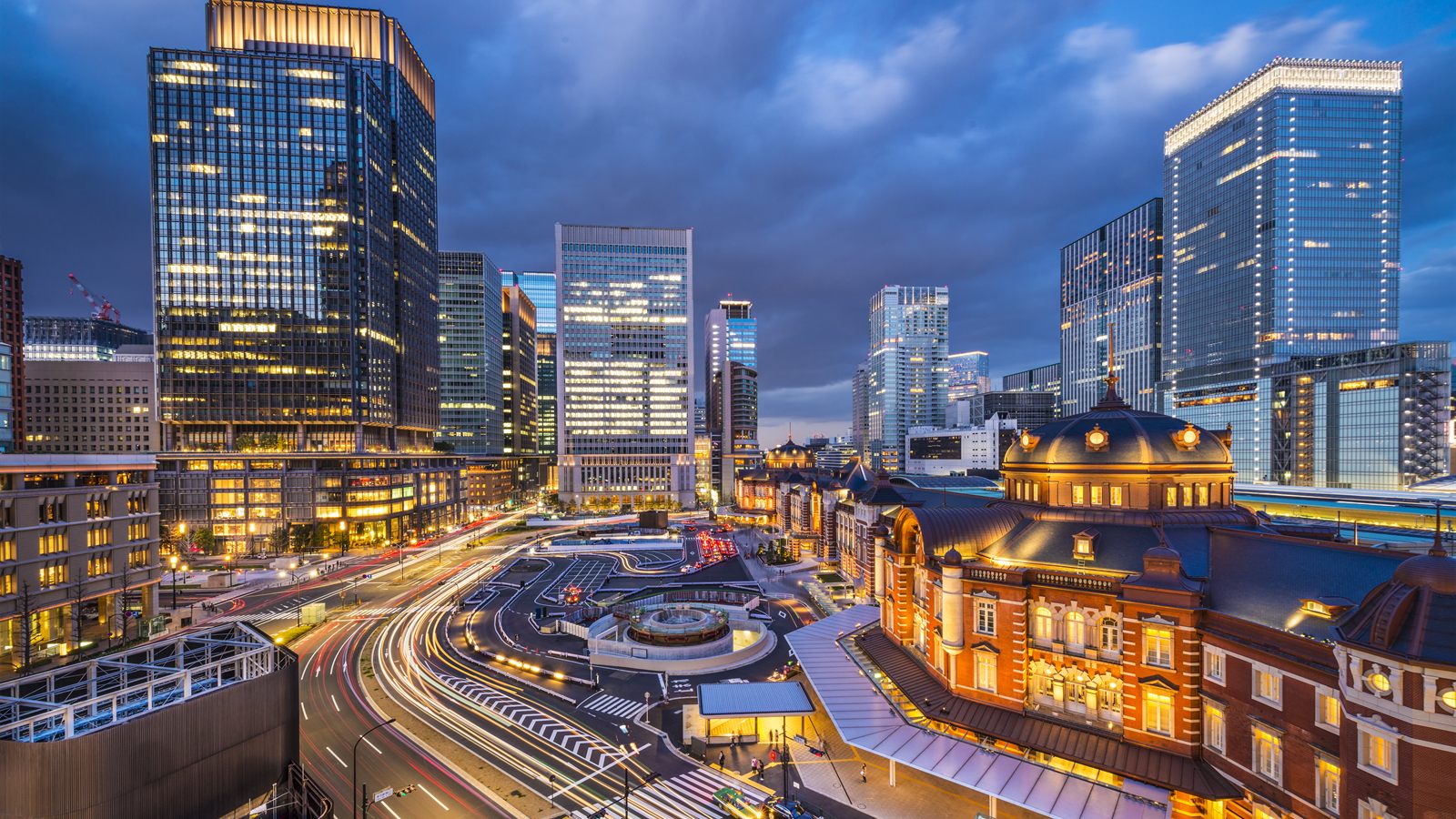 夕暮れの東京駅丸の内口と周辺のオフィス街